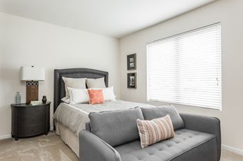 a couch and a bed in a room with a large window at 310 at Nulu Apartments-Student, Kentucky 